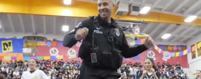 The employee of the school unexpectedly came on stage and danced in the presence of the students.